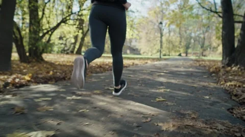 Handheld of low section of woman's legs jogging at the park Stock-Footage 244720215