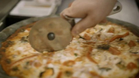 Handheld macro shot of fresh seafood pizza cut in pieces 스톡 동영상 117475604