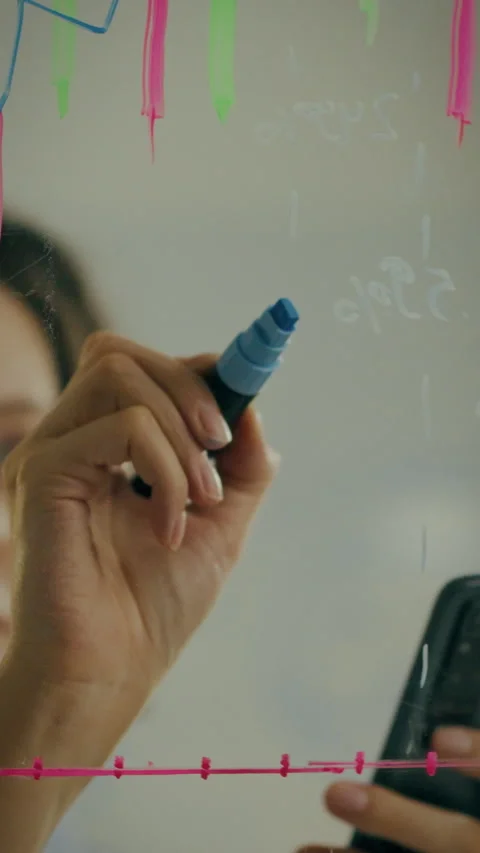 Handheld marker writing on a clear surface during a brainstorming session Stock Footage 331596773
