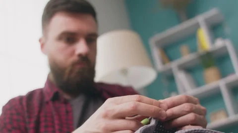 Handheld medium shot of happy man knitting at home Video stock 107355181