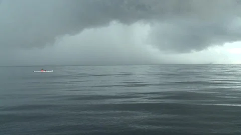 Handheld mid shot of a man kayaking while a storm is brewing Stock Footage 310540137
