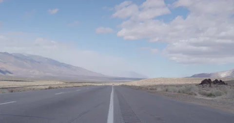 Handheld middle of empty road snowy mountain range cloudy sky Stock Footage 219331751