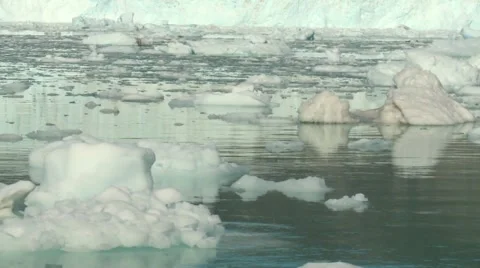 Handheld moving shot of floating ice in front of a calving glacier in Greenland Stock Footage 60004702