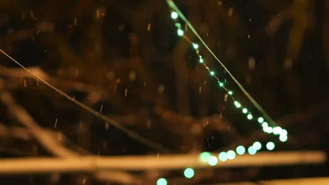 Handheld Night Snowfall with Blurred Green and White Christmas Lights, 2025 Stock Footage 325224012