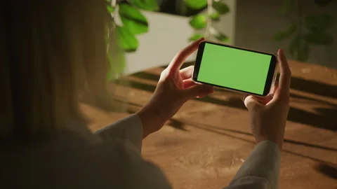 Handheld over the shoulder close up shot of a woman holding smart phone with Stock Footage 202141141