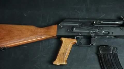 Handheld pan across an AK-47 with a banana clip and three rounds of ammo. Stock Footage 64092531