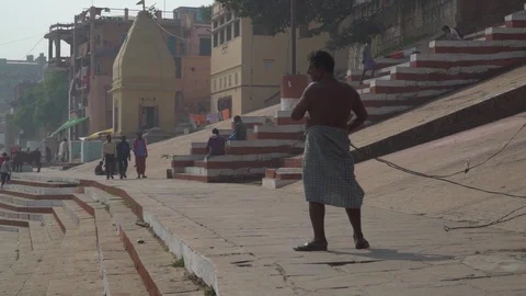 Handheld pan - man working on the street of Varanasi Stock Footage 114659787