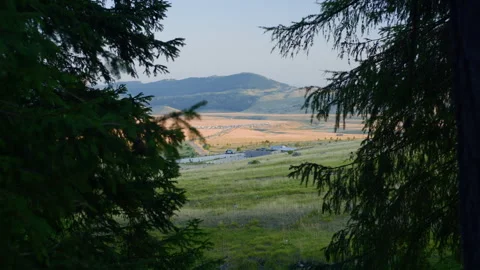 Handheld Pan of Mountain Valley with Caravan Camp from Forest Stock Footage 315802934
