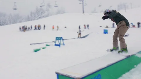 Handheld Pan Snowboarder Clears Obstacle Видео 99261509