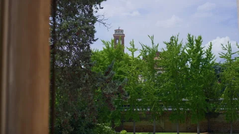Handheld Pan from Window to Garden with Trees and Brick Church Stock Footage 315770366