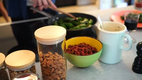 Handheld panning shot of man's hand mixing green chilli peppers on frying pan 스톡 동영상 114883665