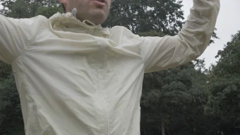 Handheld panning shot of young man doing jumping jacks Video stock 114843783