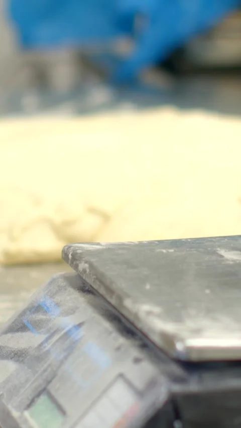 Handheld phone documenting dough on dusty stainless bakery scale from low Видео 344573816
