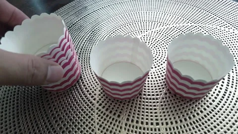 Handheld. Placing the empty stripe paper cups on the table. Stock Footage 159582461