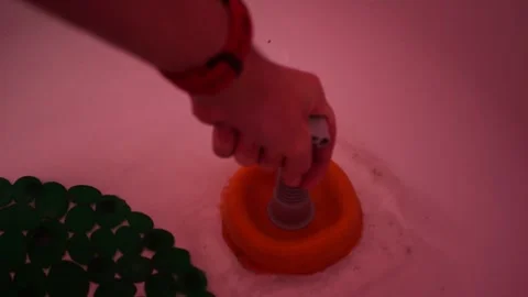 Handheld plunger close up clearing white bathtub drain splashing gurgling sounds Stock Footage 320896346