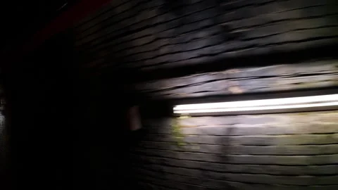 Handheld point of view moving through a dark, brick passageway Stock Footage 329572980