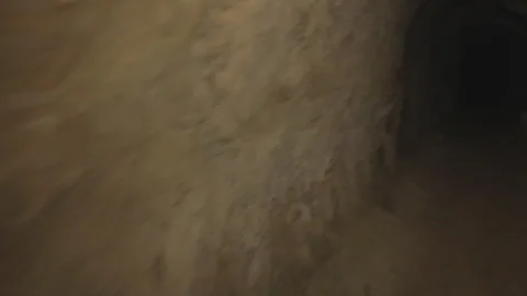 Handheld POV walking through dark cave with outstretched hand Stock Footage 252354249