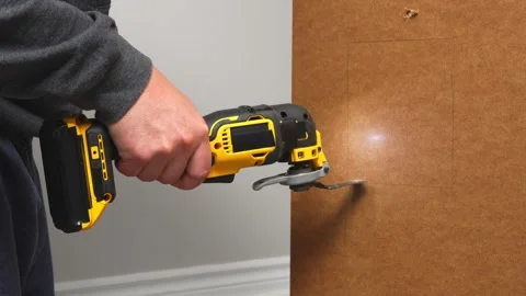 Handheld power tool is cutting through a wooden surface, showcasing the precise Stock Footage 323991238