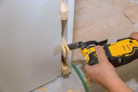 Handheld power tool cutting through wood with precision in home renovation Stock Photos
