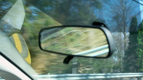 Handheld Rear View Mirror Reflection of Scenic Spring Road and Trees Stock Footage 332498393