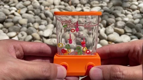 Handheld retro water game ring swirl arcade. Nostalgic fun toy fish food Stock Footage 205817187