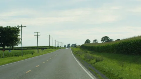 Handheld of rural road going through farms in Iowa 動画素材 136863120