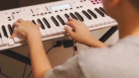 Handheld shot of Asian boy practice his piano lesson at home Video stock 107936662