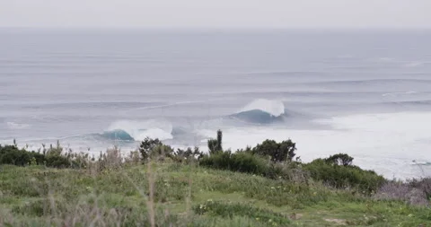 Handheld shot of beach with ocean waves splashing and moving in slow motion Video stock 163063015