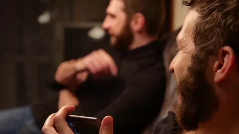Handheld shot of bearded man telling story to surprised friend Stock Footage 72835484