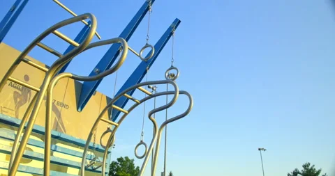 Handheld shot bottom up view of outdoor gynastics rings swinging Stock Footage 202105959