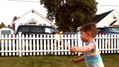 Handheld shot of a boy running with a sparkler Stock Footage 114884793