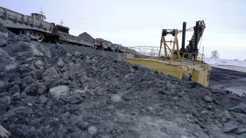 Handheld shot of bulldozer unloading freight train with copper ore at the Stock Footage 75069650