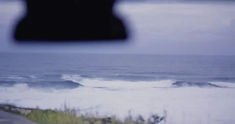 Handheld shot from car of ocean water swaying back and forth across land Video stock 156111453