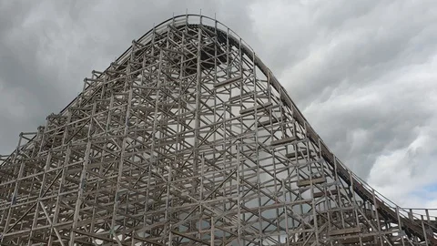 Handheld shot of a cart going down a tall wooden roller coaster hill. Video stock 116215352