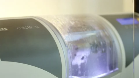 Handheld shot of cerec machine creating a dental crown Stock Footage 113717394