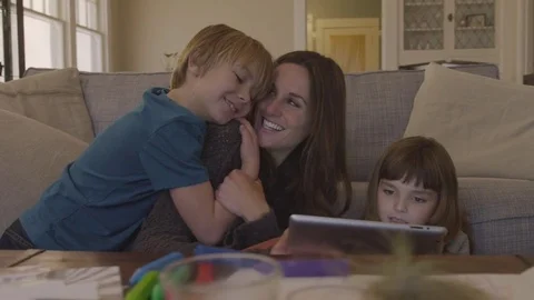 Handheld shot of cheerful mother with children video conferencing over tablet Stock Footage