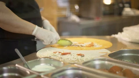 Handheld shot of chef hands in white gloves making two doners in pita 動画素材 121853517
