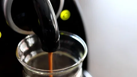 Handheld shot of coffee being poured into jar from coffee maker 스톡 동영상 114848779