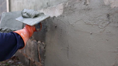 Handheld shot of construction workers plastering cement during the constructi Stock Footage 205541922