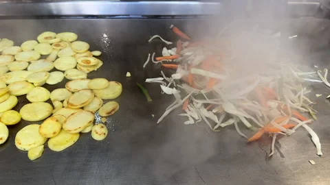Handheld shot. Cooking vegetables on griddle plate or hot plate 動画素材 246232844