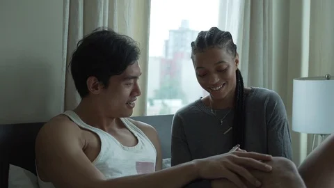 Handheld shot of couple laughing while looking at mobile phone in slow motion Stock-Footage 114878541