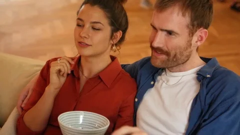 Handheld shot of a couple talking while watching TV in the living room Stock Footage 114846854