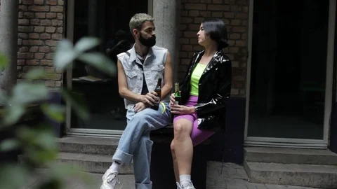 Handheld shot of a couple talking while sitting outdoors Vídeo Stock 114846981