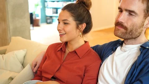 Handheld shot of couple talking while sitting on the sofa Video stock 114884638