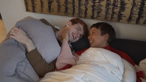 Handheld shot of couple talking while lying on the bed Stock Footage 120436629