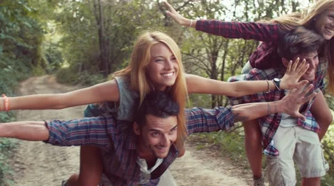 Handheld shot of couples having fun with piggyback ride Stock Footage 55278664