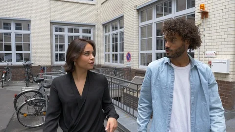 Handheld shot of creative man and woman talking while walking in parking area 스톡 동영상 114872171