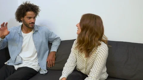 Handheld shot of creative young man and woman talking while sitting on sofa Video stock 114872041