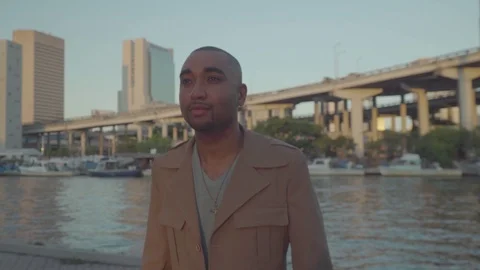 Handheld shot of a determined man walking near a river in a city. Stock-Footage 126054365