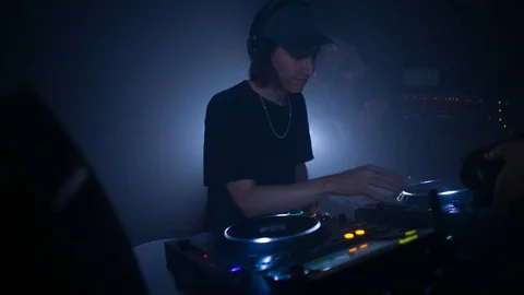 Handheld shot of DJ accessing DJ controller and reacting to the request Stock Footage 115090348